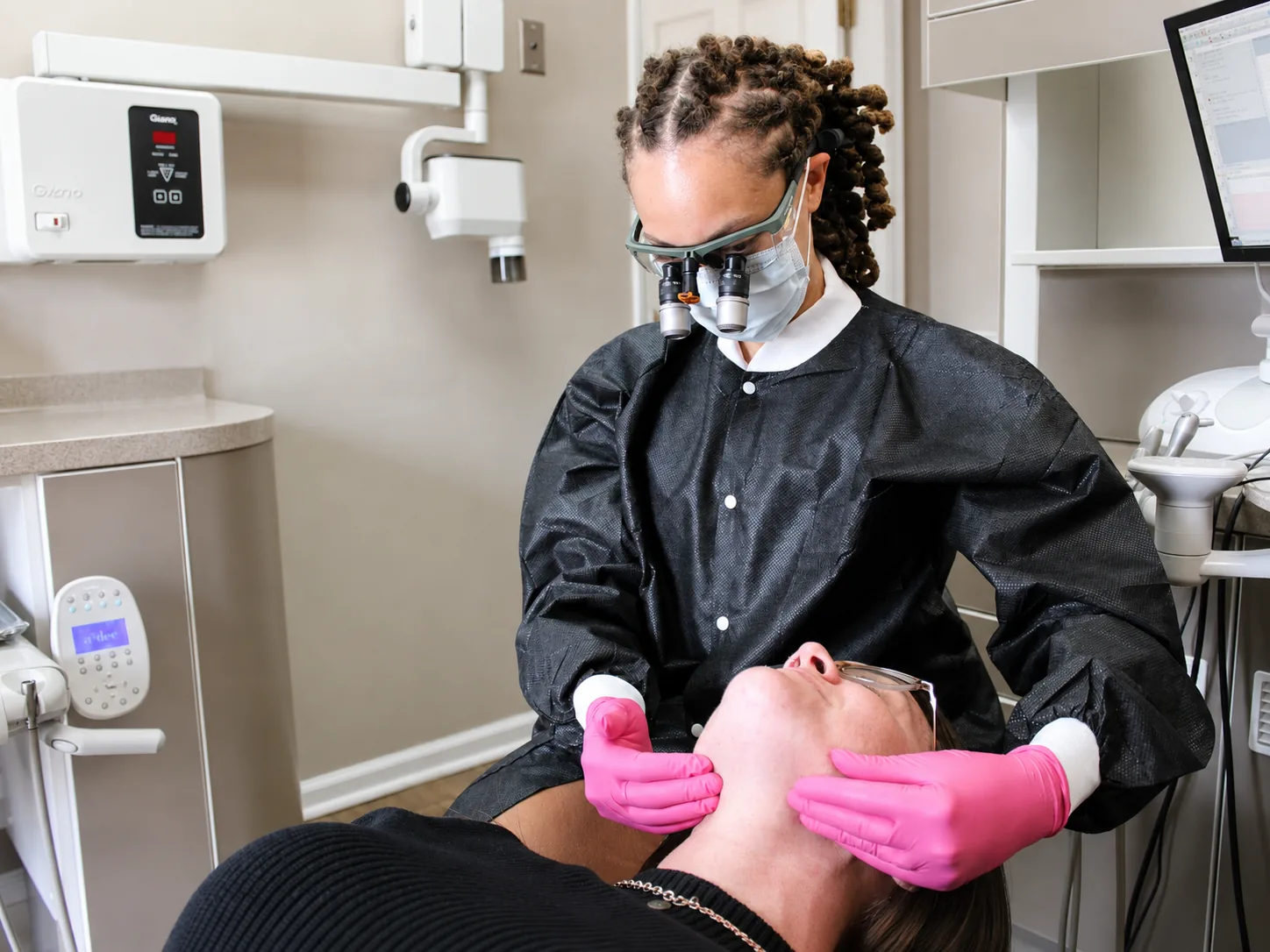 Dr. Paris Little wearing magnification loupes during a focused dental exam in McDonough, Georgia