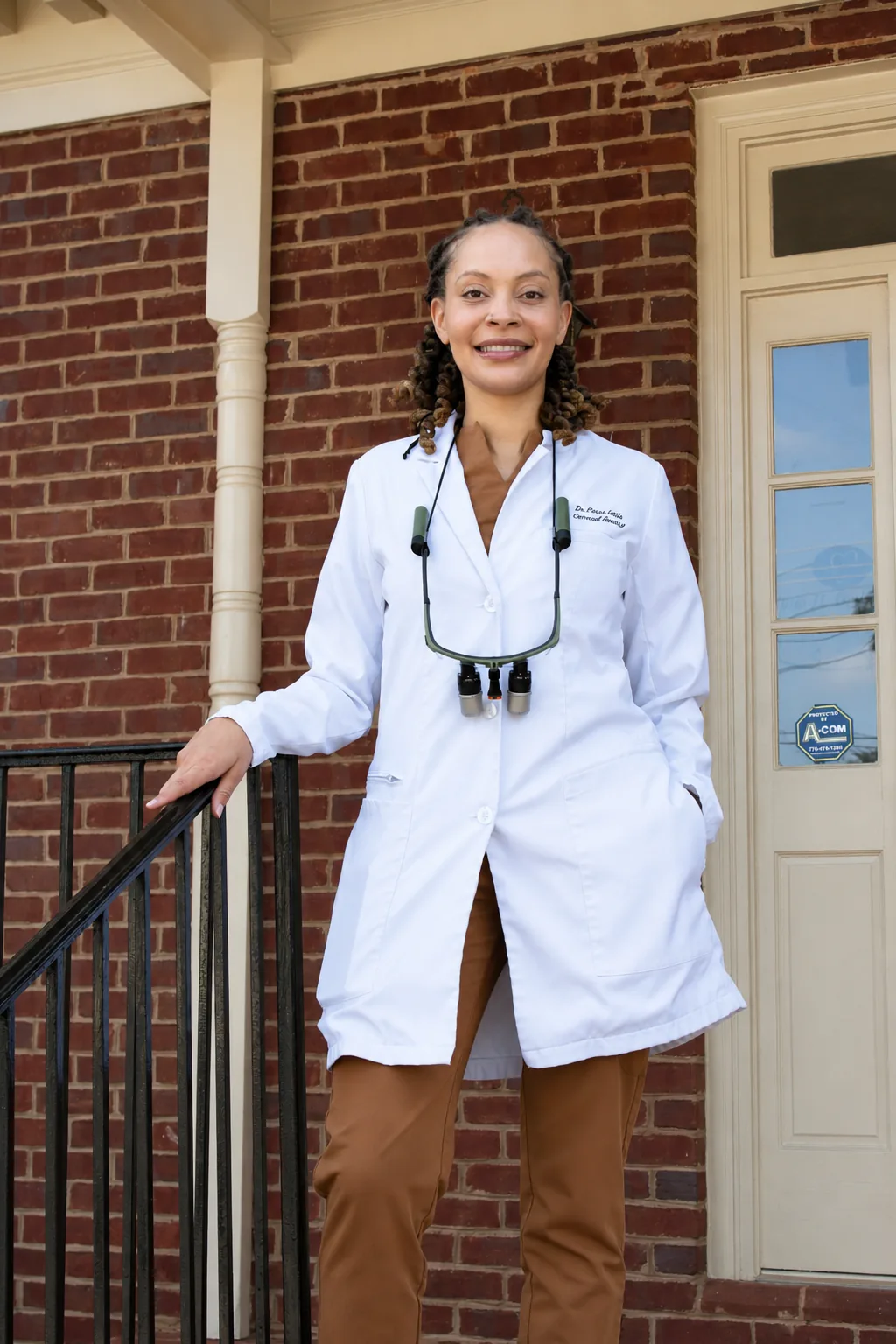 Dr. Paris Little smiling on the front steps of Clarity Dental in McDonough, Georgia