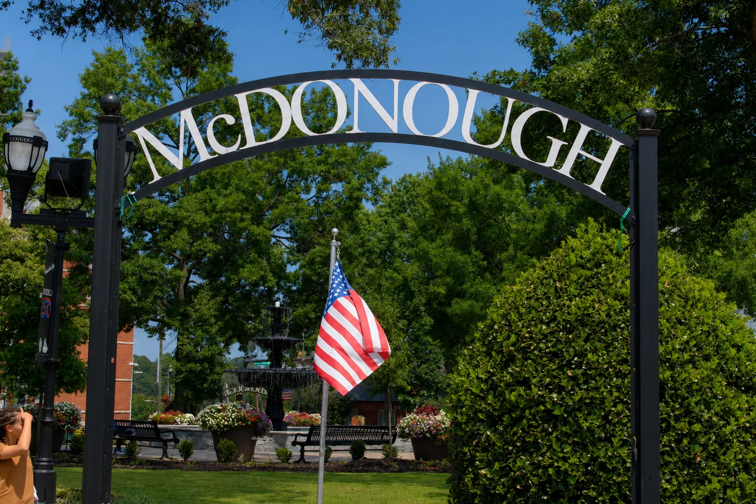 The McDonough arch sign and American flag at the town square in McDonough, Georgia